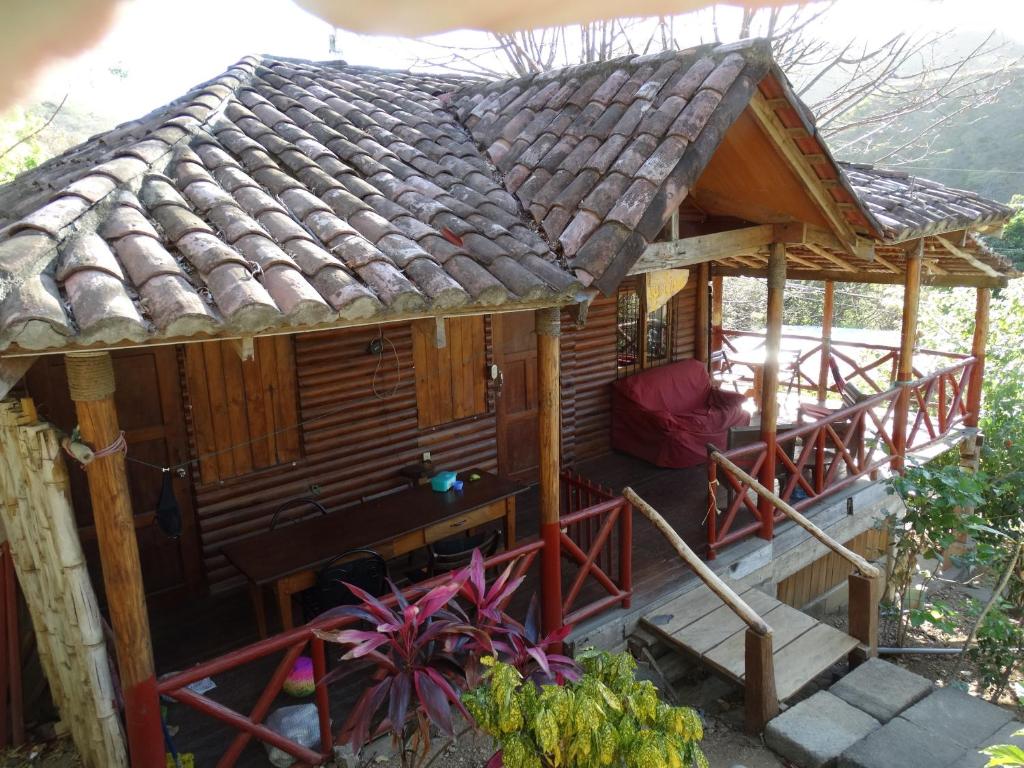 une maison en bois avec un toit de chaume dans l'établissement 2 bedroom cottage, 3 blocks from beach and center of San Juan, à San Juan del Sur
