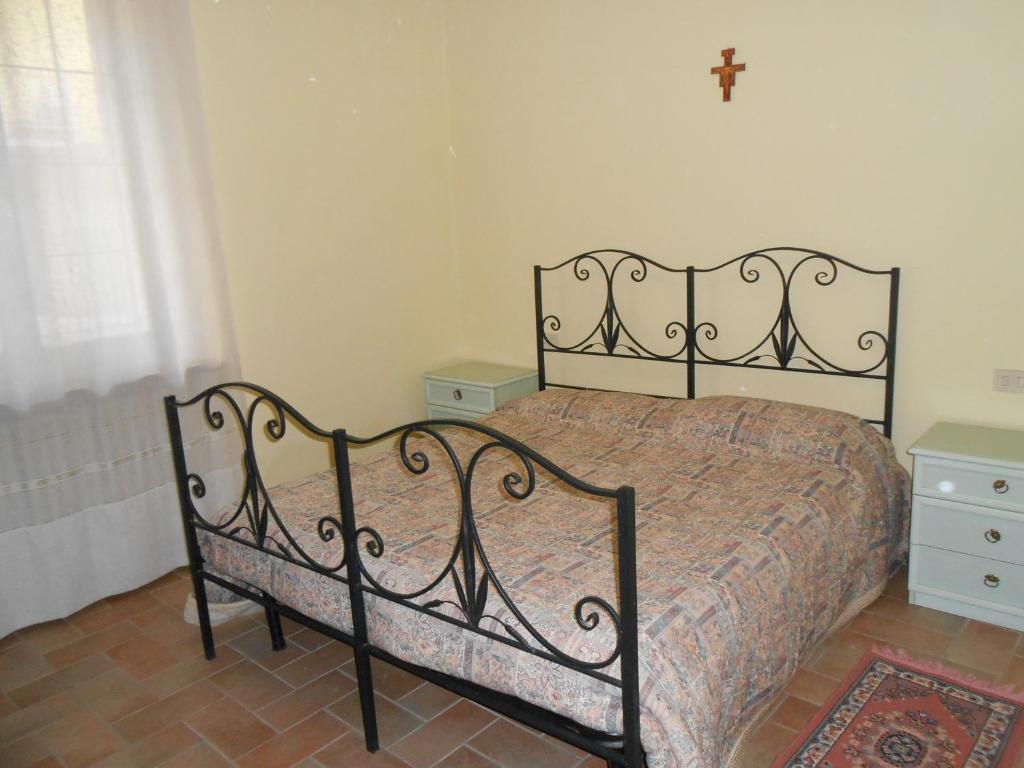 a bed in a bedroom with a cross on the wall at Garden in Bastia Umbra