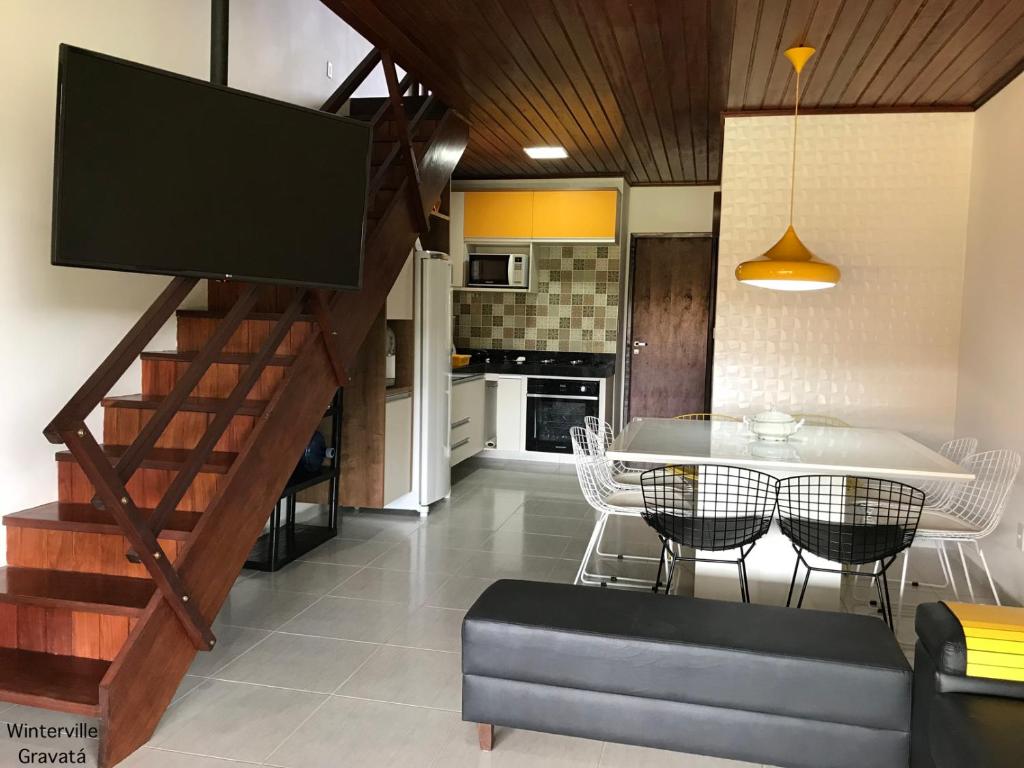 uma cozinha e sala de jantar com uma escada e uma mesa em Winterville Gravatá - Flat 1012 em Gravatá