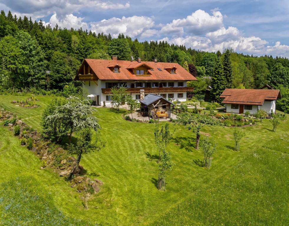 施皮格勞的住宿－Haus Jägerfleck, Ihre Ferienwohnungen am Nationalpark Bayerischer Wald，田野上大房子的空中景观