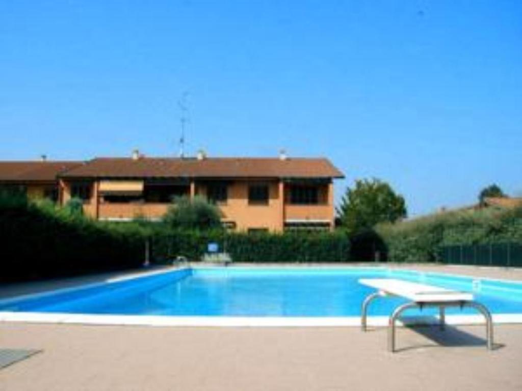 a swimming pool with a bench in front of a house at Sirmione Confort Easy in Sirmione