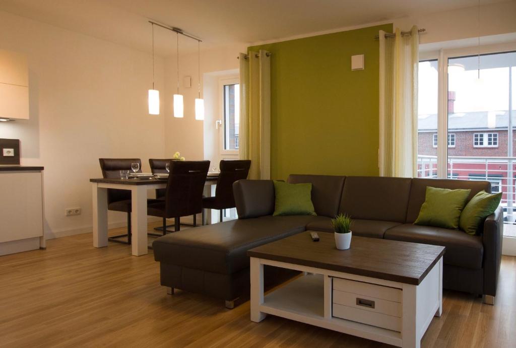 ein Wohnzimmer mit einer Couch und einem Tisch in der Unterkunft Wohnen am Yachthafen W45 in Cuxhaven