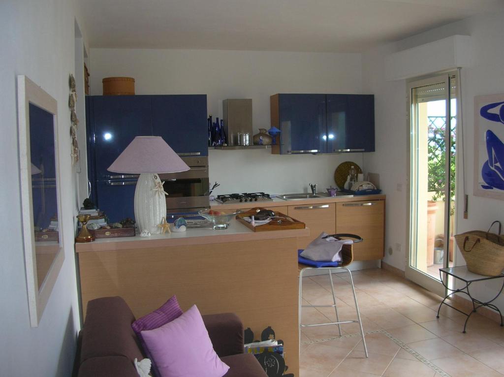 a kitchen with blue cabinets and a couch in a room at la scappatoia in Cavo