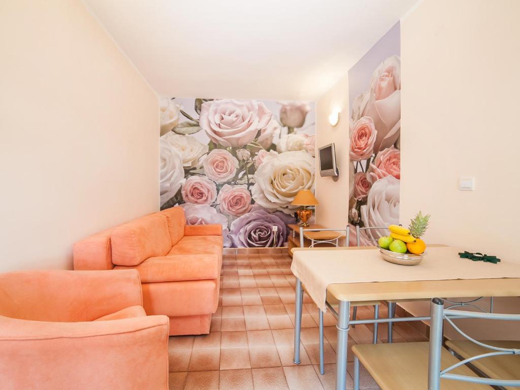 a living room with a wall mural of roses at Apartments Raymond in Sveti Stefan
