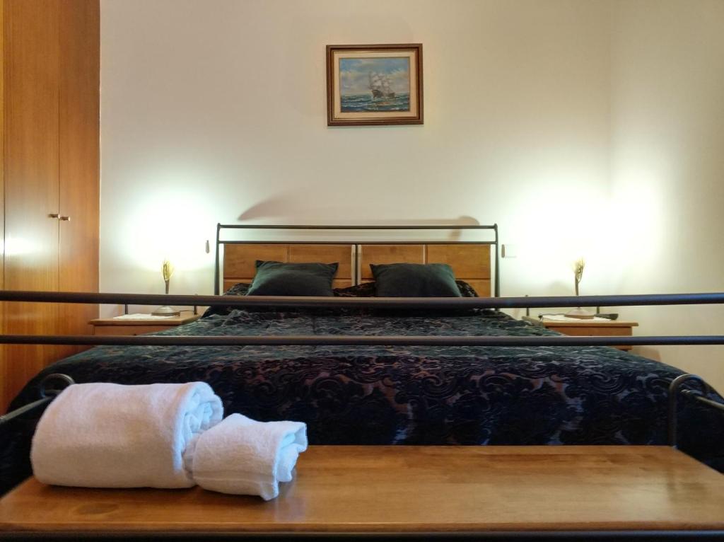 een slaapkamer met een bed en handdoeken op een tafel bij Casa De Fora in Aboim