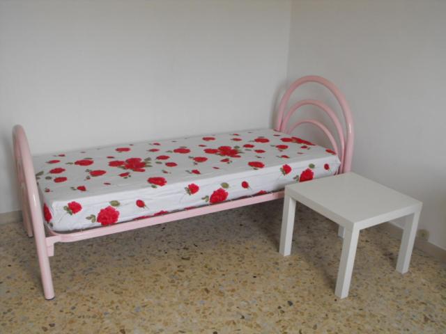 カタンザーロにあるIl Filo Di Ariannaのテーブルの横に赤い花が飾られたおもちゃベッド