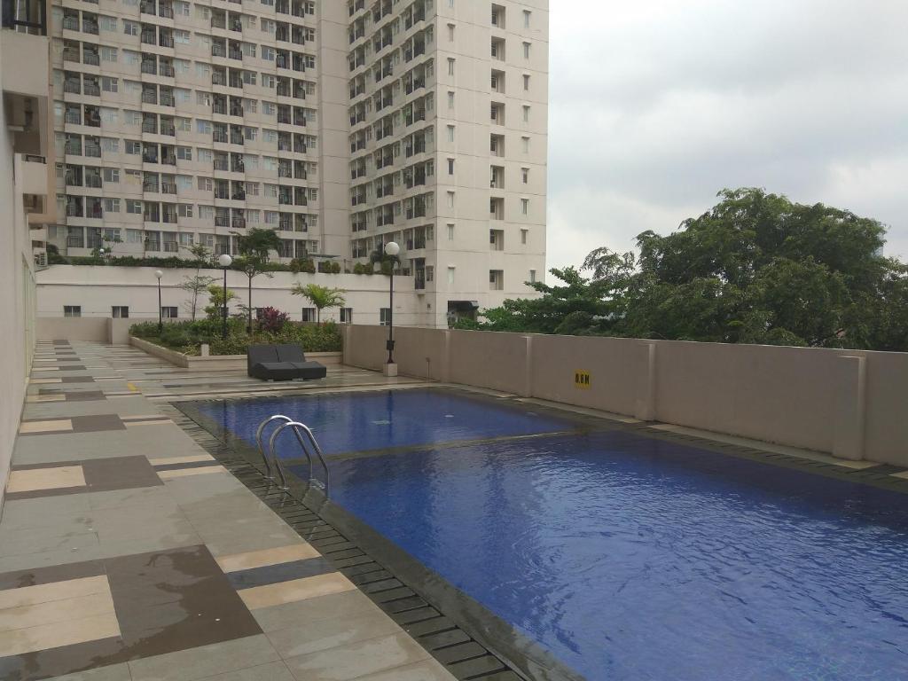una piscina en medio de dos edificios altos en DSR Margonda Residence 3 Apartment en Depok