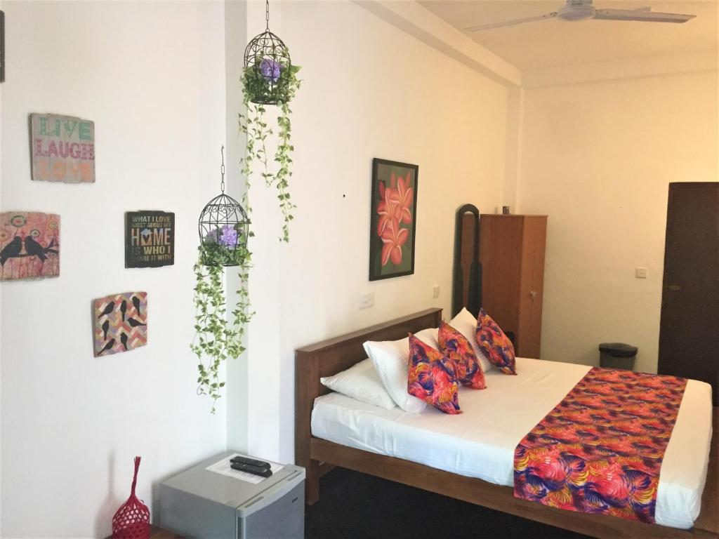 a bedroom with a bed and some plants on the wall at Anara Villa in Unawatuna