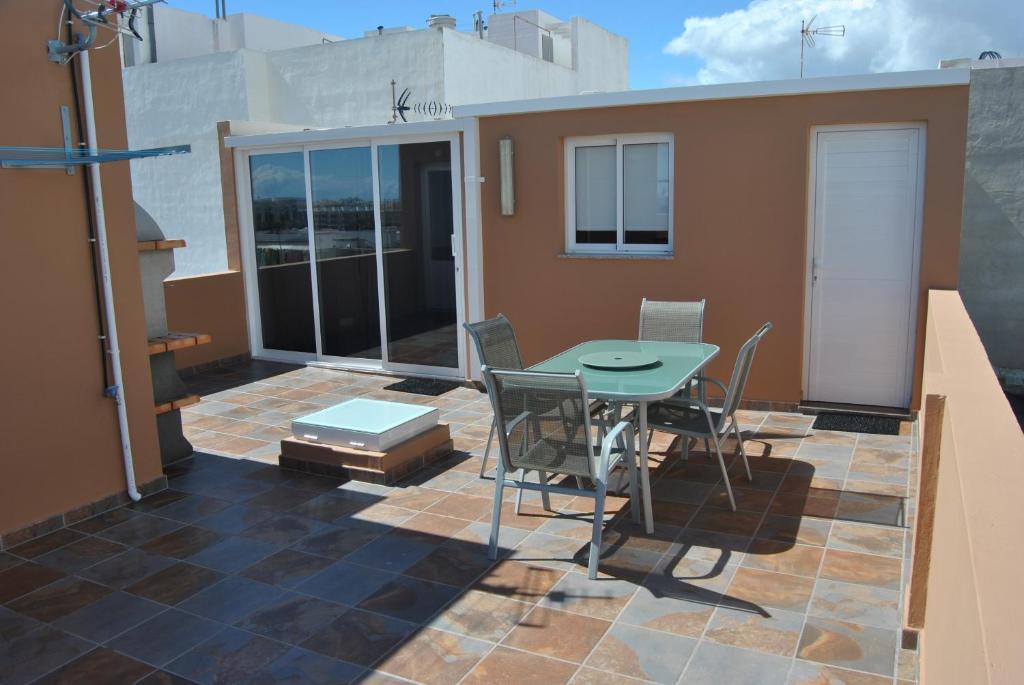 una casa con patio con mesa y sillas en Ático Tanausú en Arrecife