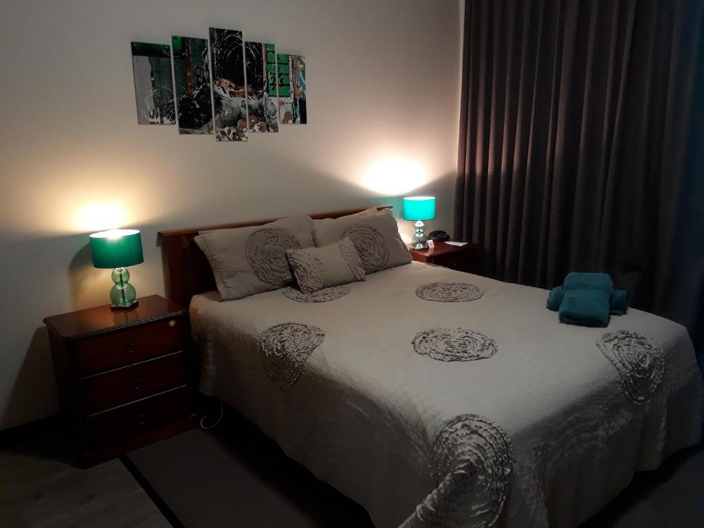 una camera da letto con un letto con due lampade sopra di Moe Motor Inn - Contactless 24 hour Checkinn Available a Moe