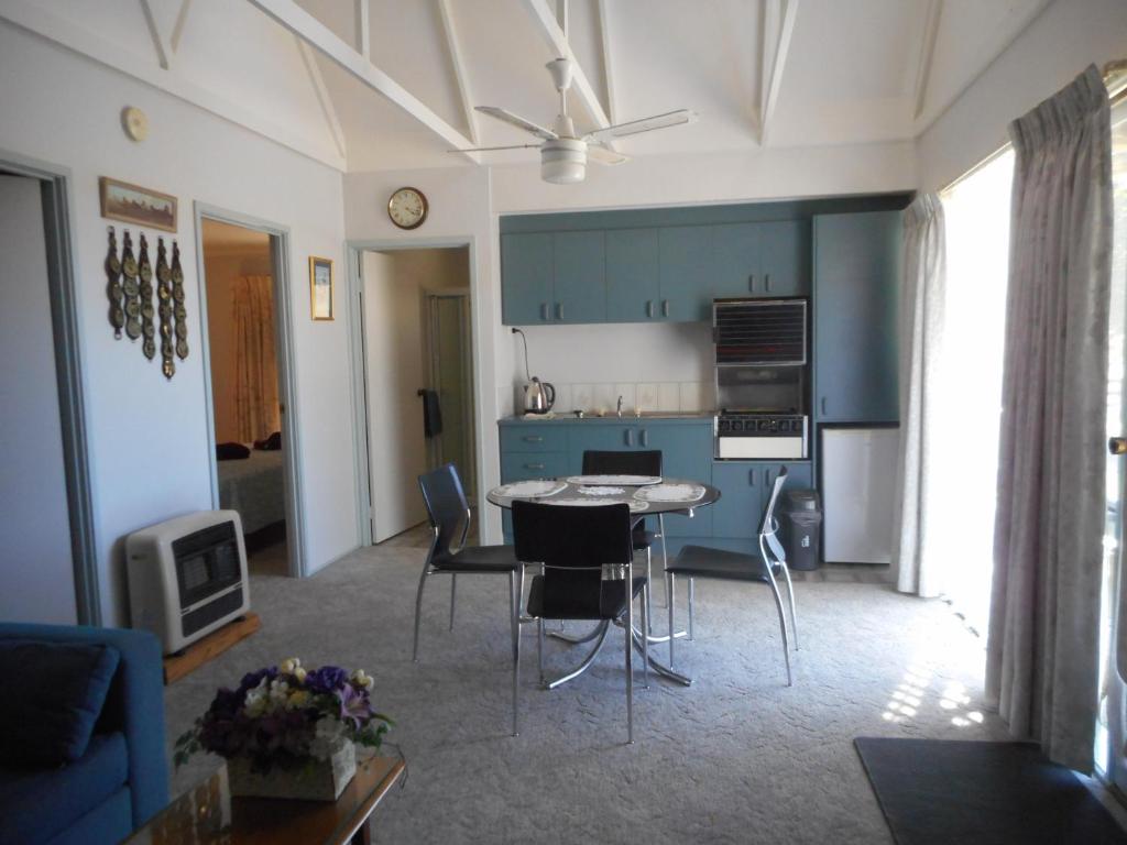 a kitchen and living room with a table and chairs at Glenfield Cottage in Yarck