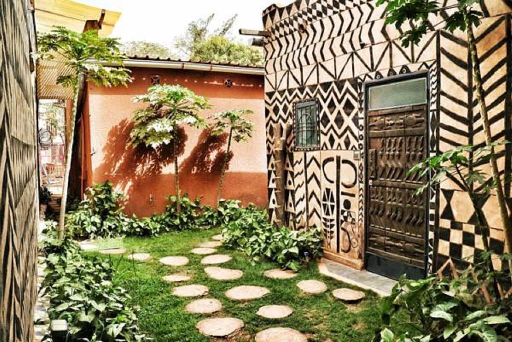 Maison d'hôtes Chez Giuliana في واغادوغو: حديقة بها مسار أمام المنزل