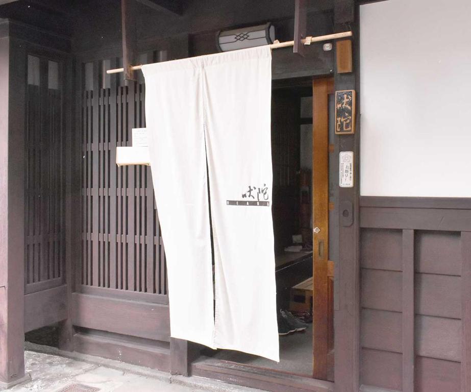 una cortina blanca colgando fuera de un edificio en Veada, en Kioto