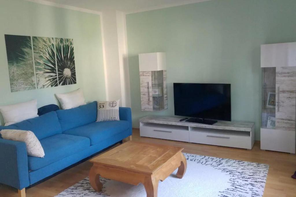 un soggiorno con divano blu e TV di Familientraum innen Stadt a Brema