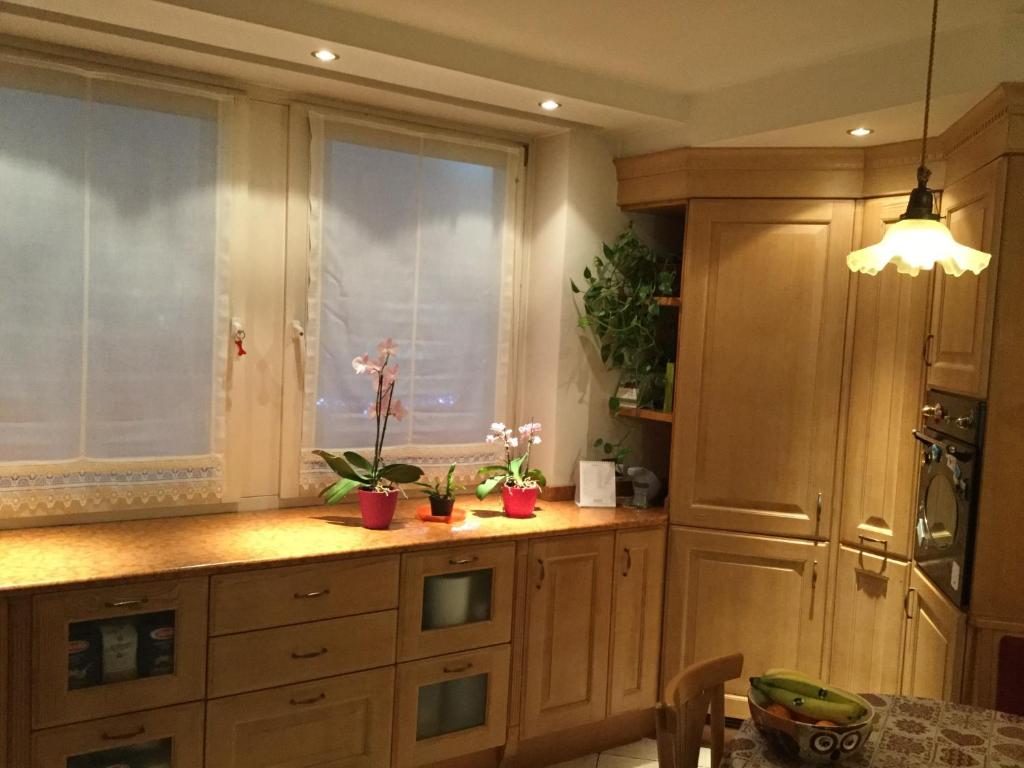 una cocina con armarios de madera y una ventana en Casa Andreis, en Malè
