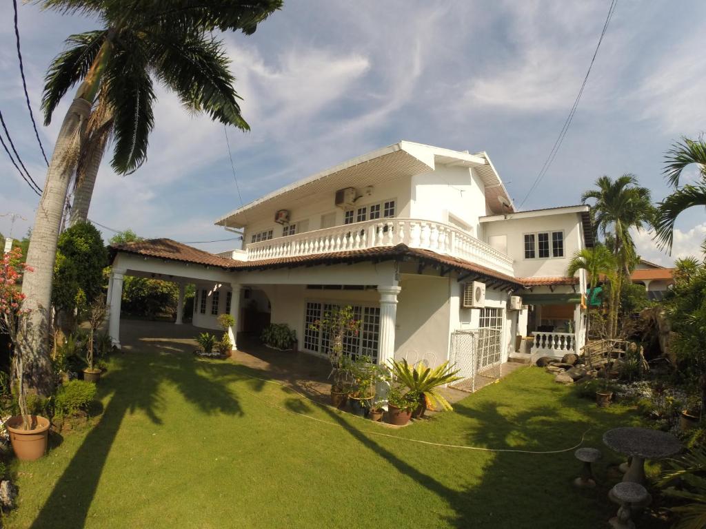 ein weißes Haus mit einer Palme im Hof in der Unterkunft Casa Impiana in Kuantan