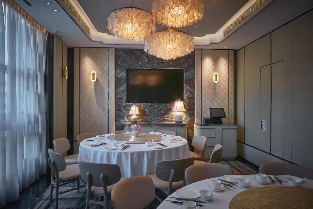Camera con tavolo, sedie e TV di The Emperor Hotel a Hong Kong