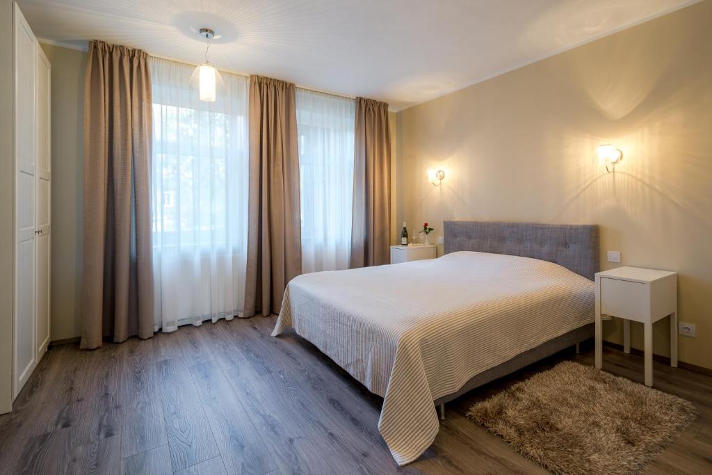 a bedroom with a bed and a large window at Kolumbs Junior Suite in Liepāja