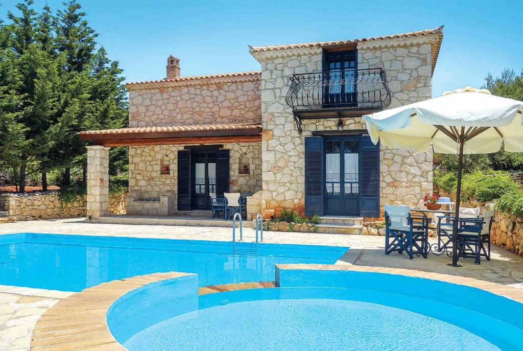 a villa with a swimming pool in front of a house at Niovi in Agios Leon