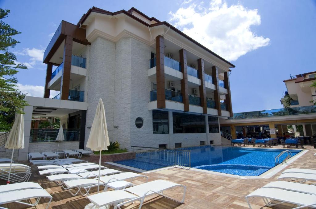 a hotel with a swimming pool and lounge chairs at Supreme Hotel in Marmaris