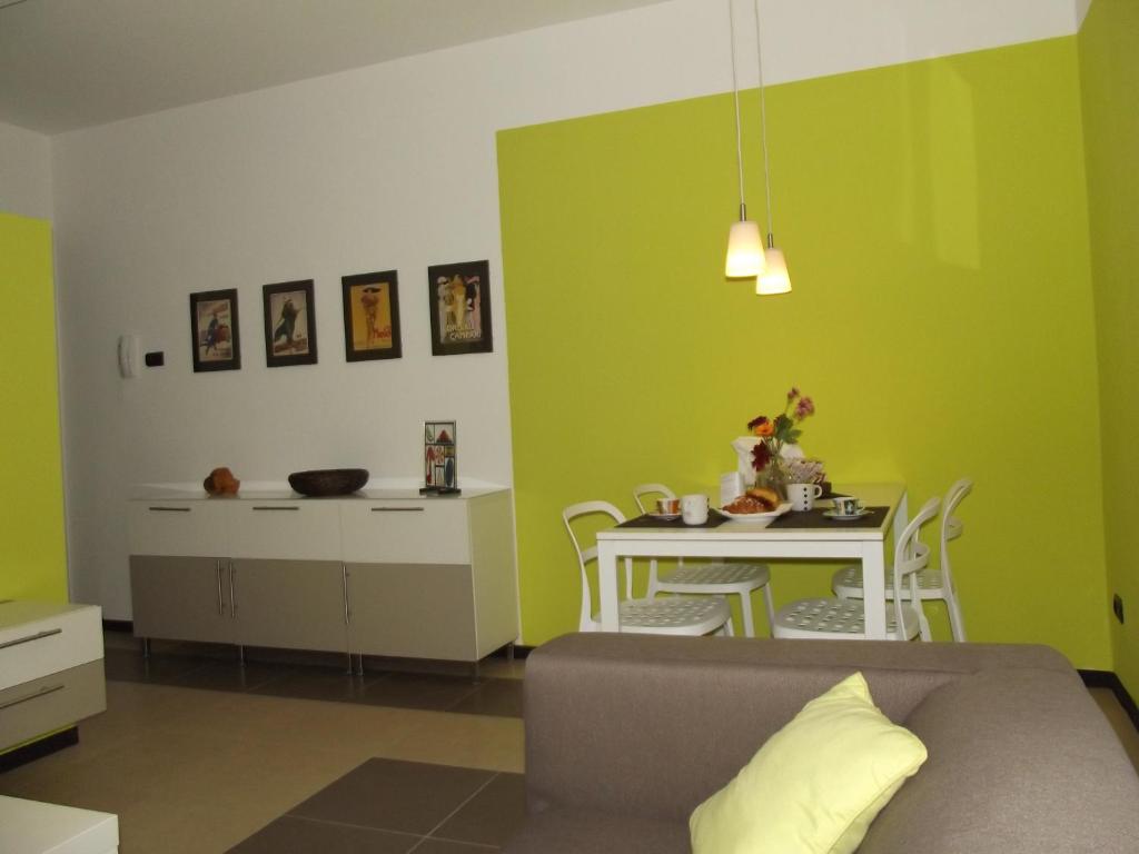 sala de estar con paredes verdes, mesa y sofá en Cimarhosa House, en Rho