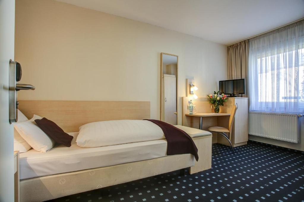 Postel nebo postele na pokoji v ubytování Rhein Neckar Hotel