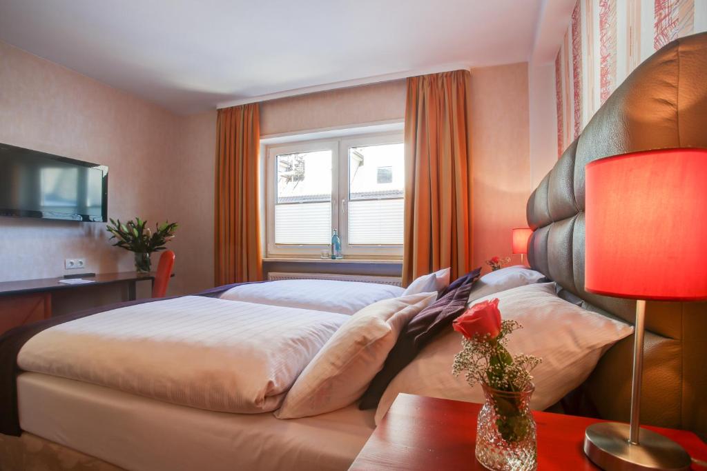 a bedroom with a large bed and a window at Rhein Neckar Hotel in Mannheim