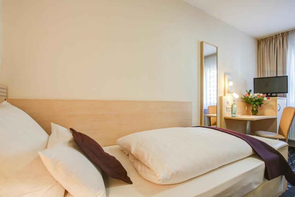 Postel nebo postele na pokoji v ubytování Rhein Neckar Hotel