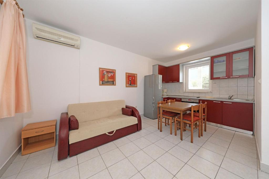 a kitchen with a couch and a table in a room at Apartments Karolina in Novalja