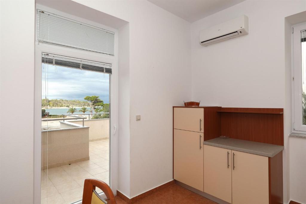 a kitchen with a counter and a window with a view at Apartments Karolina in Novalja