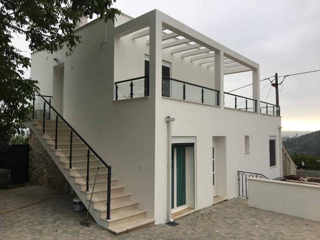 a white house with a staircase in front of it at Villa Santo Antonio in Serra do Mouro