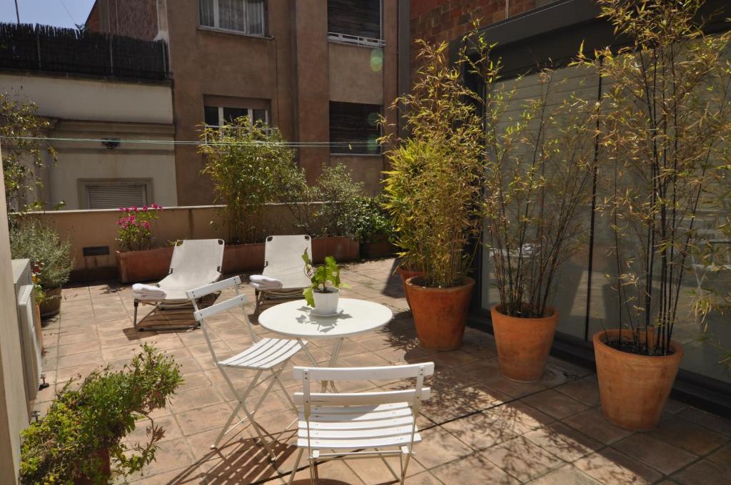 une terrasse avec une table, des chaises et des plantes dans l'établissement RentBCN Gracia Deluxe, à Barcelone