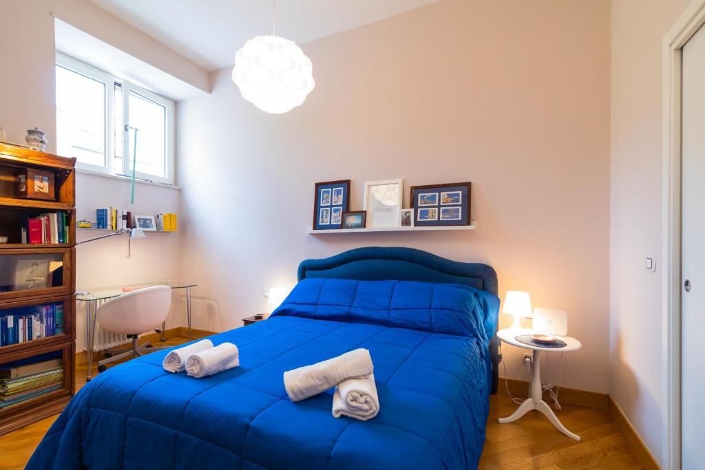 a bedroom with a blue bed with towels on it at Elegant Flat at Municipio by Napoliapartments in Naples