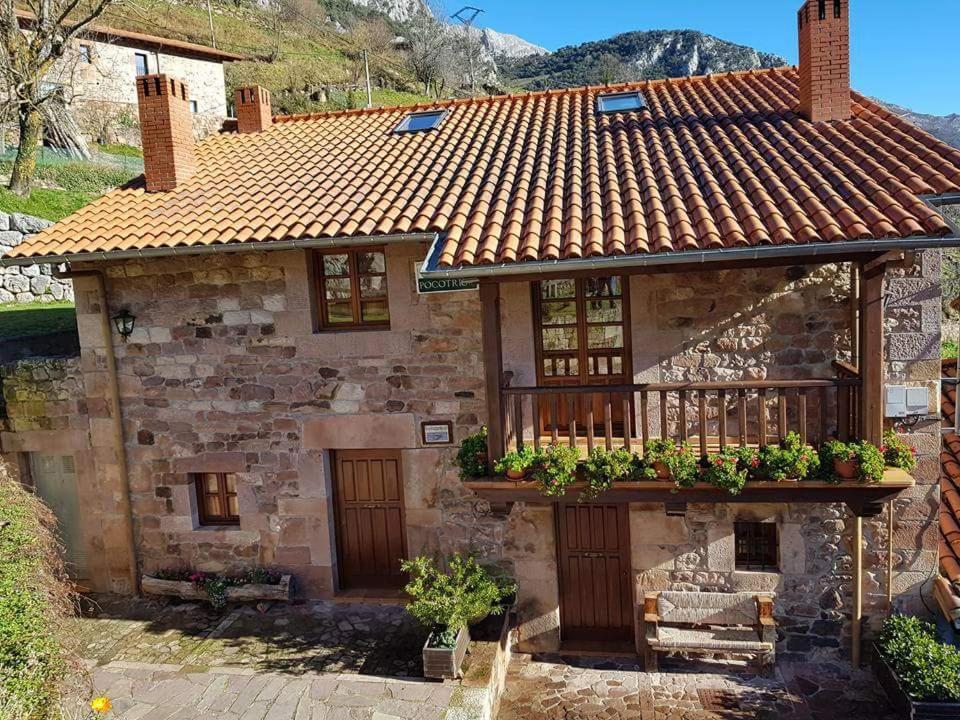 Casa de piedra antigua con porche y balcón en Casa Rural Pocotrigo en Linares