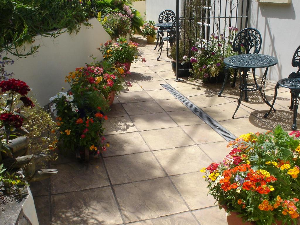 a patio filled with lots of different types of flowers at Rosedene Guest House in Pembroke
