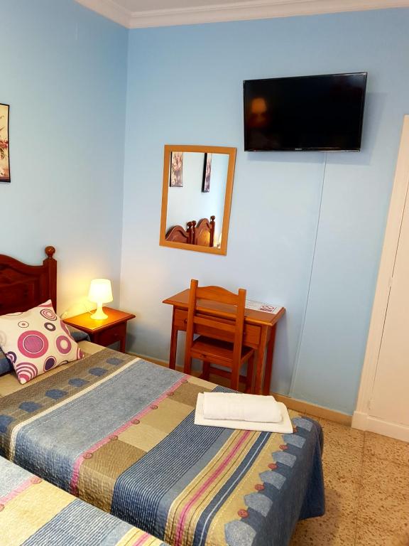 a bedroom with a bed and a television on the wall at Sanvi Xerez Centro in Jerez de la Frontera