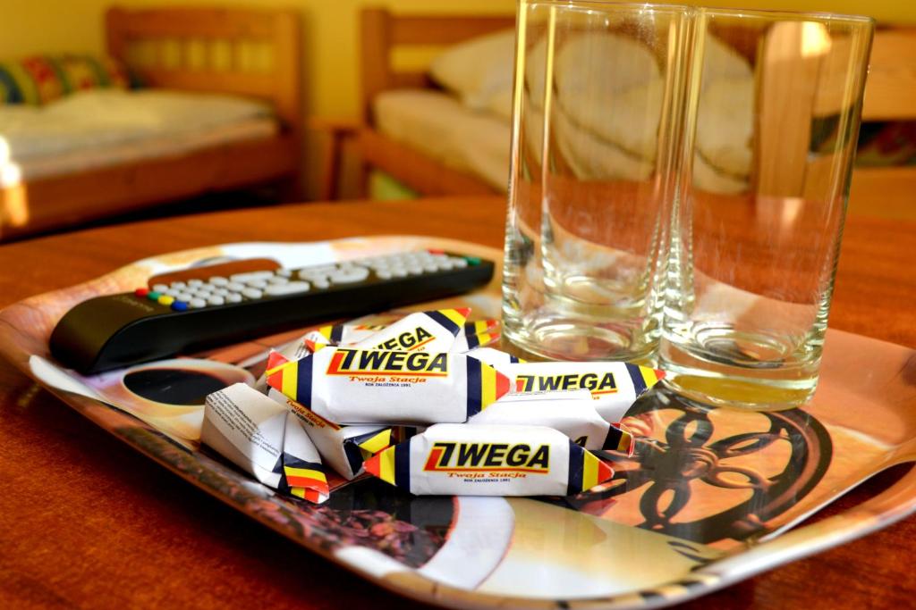 a plate with a remote control and a glass at Noclegi Wega in Częstochowa