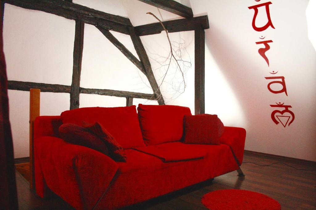 クヴェードリンブルクにあるReikistudio "Auszeit"の壁に書物がある部屋の赤いソファ