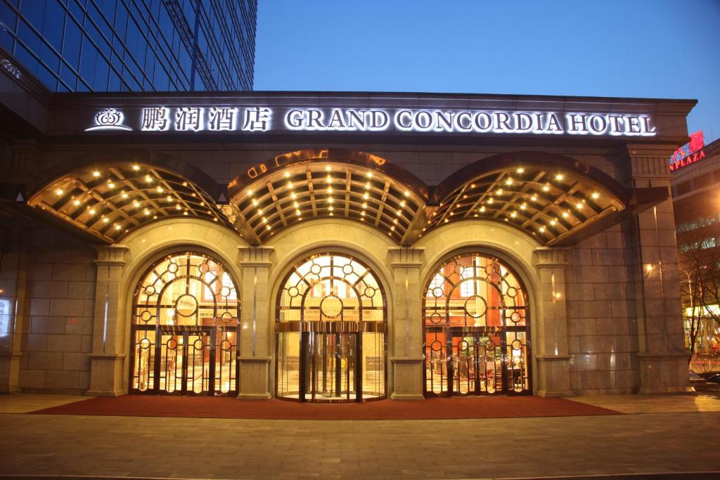 a grand concourse of a building with large windows at Grand Concordia Hotel in Beijing