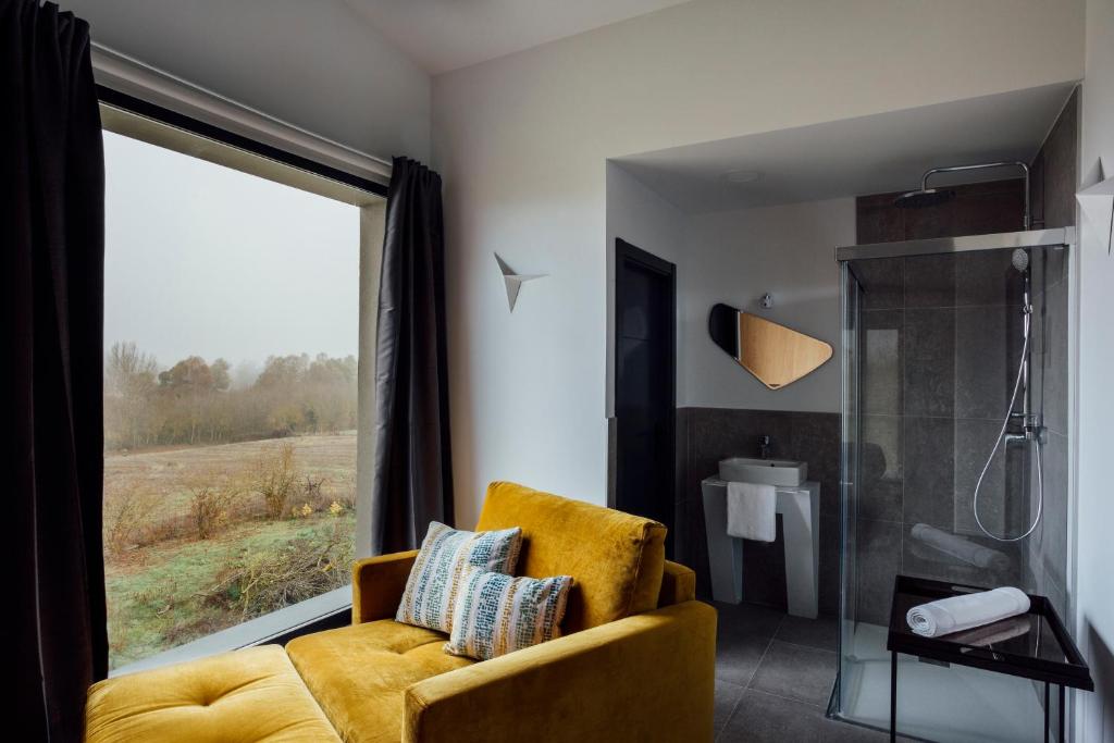 a bathroom with a yellow chair and a shower at Mirador Ardea Mendixur in Mendijur