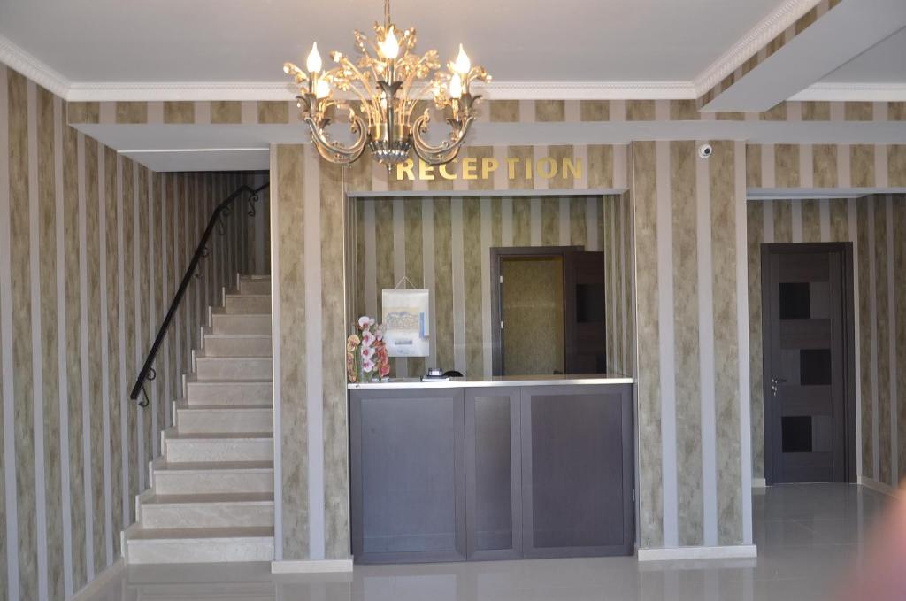 a lobby with a staircase and a chandelier at Hotel New Telavi in Tʼelavi