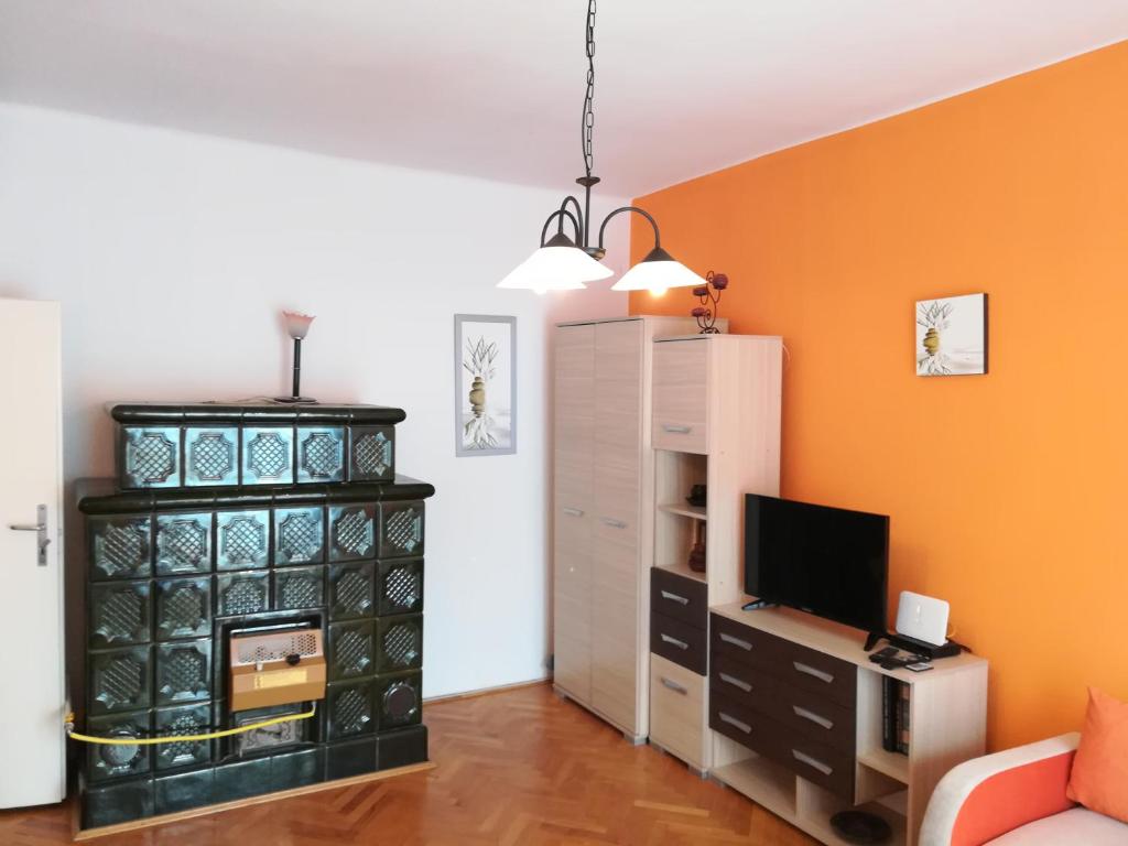 Liszt Apartman في زومباثلى: غرفة معيشة مع جدار برتقالي
