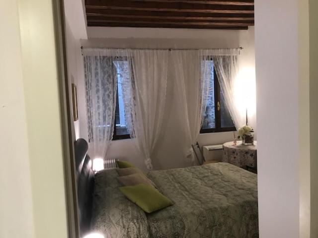 1 dormitorio con 1 cama y 2 ventanas en Carina House en Venecia