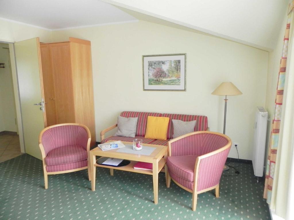 アールベックにあるFerienwohnung 1 3 19 Inselstrandのリビングルーム(ソファ、椅子2脚、テーブル付)