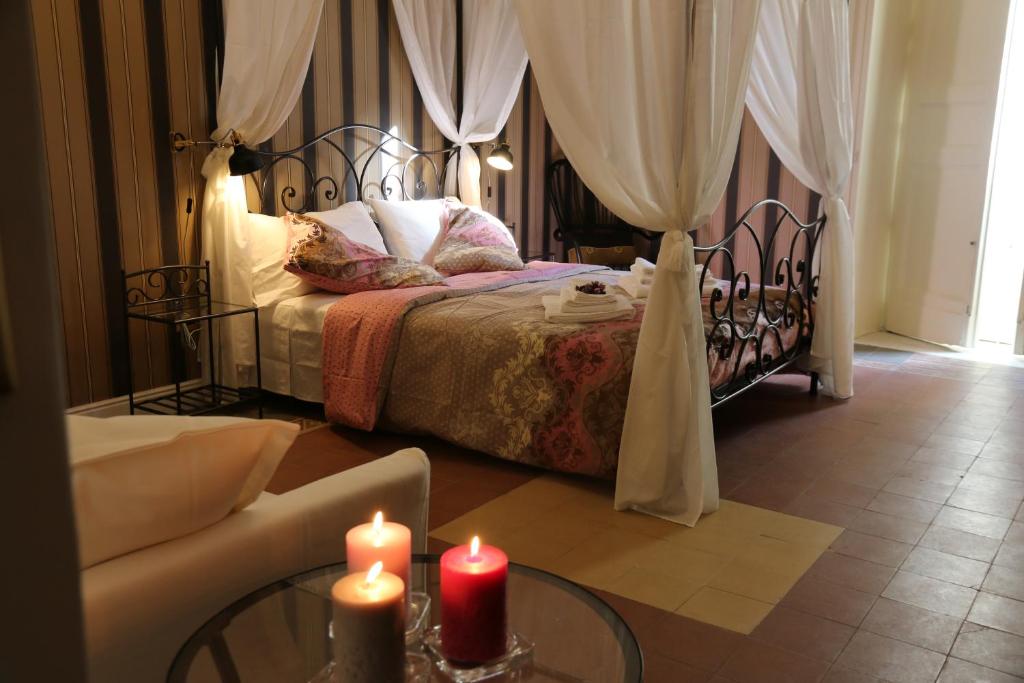 Un dormitorio con una cama con dos velas. en Aitna B&B, en Catania