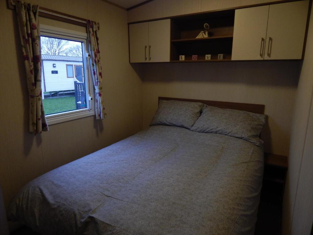 Kirby MispertonにあるFlamingo Land - Woodlands W42の小さなベッドルーム(ベッド1台、窓付)