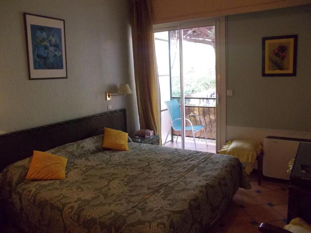 Postel nebo postele na pokoji v ubytování Hôtel Les Alizés