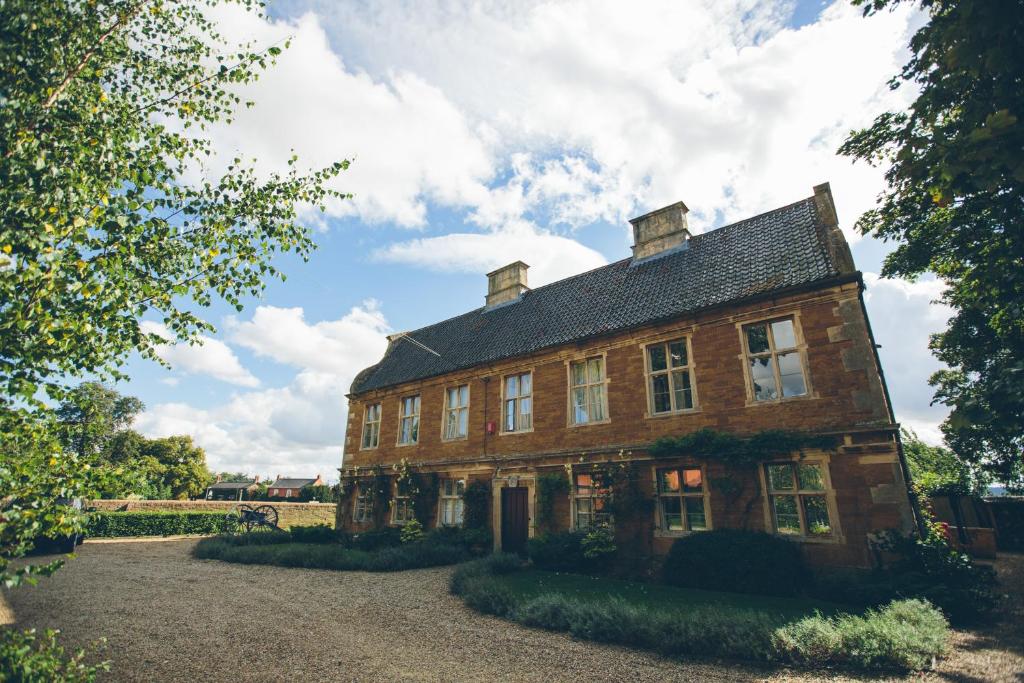 ein altes Backsteinhaus mit schwarzem Dach in der Unterkunft Allington Manor in Allington