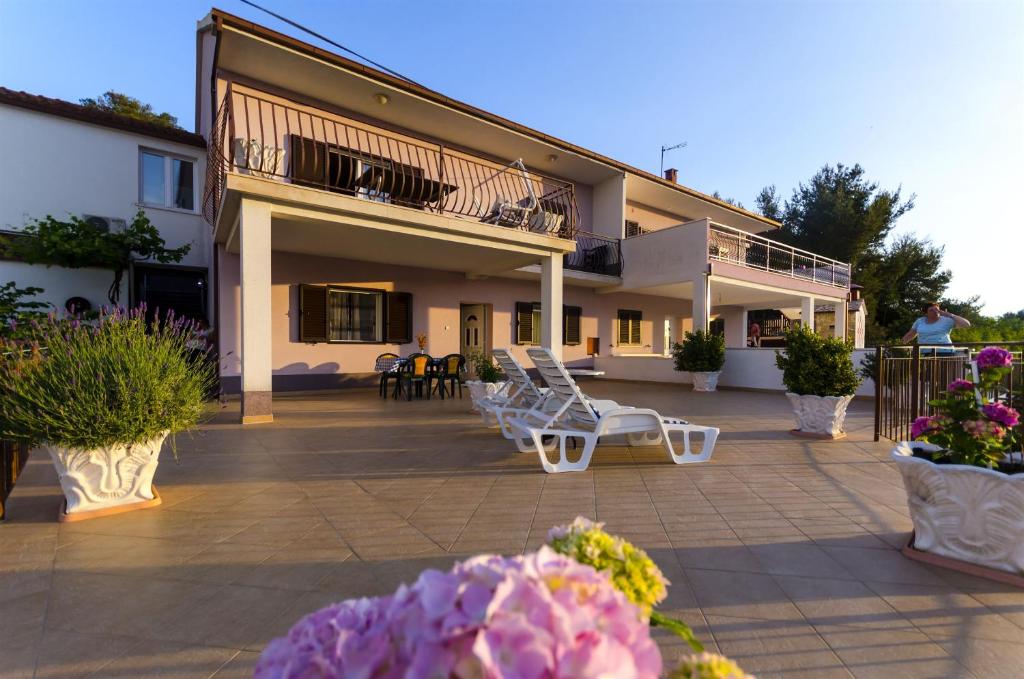 een huis met twee witte stoelen op een patio bij Apartment Marijana in Trogir