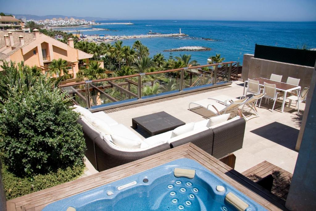 a hotel room with a balcony overlooking the ocean at GRAN HOTEL GUADALPIN BANUS, Marbella in Marbella